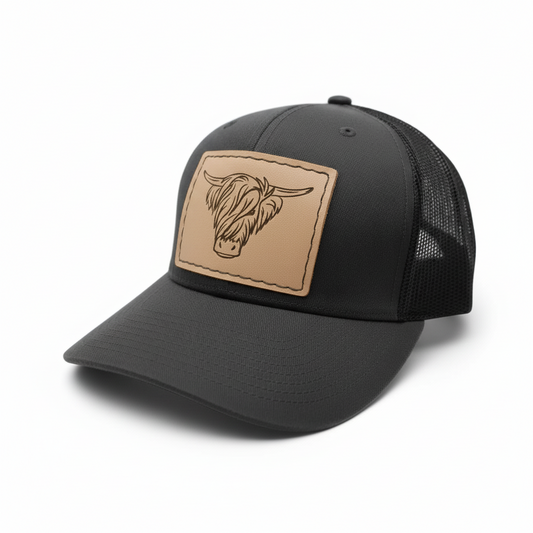 Black trucker cap with a brown leather patch featuring a bull's head on a light gray background