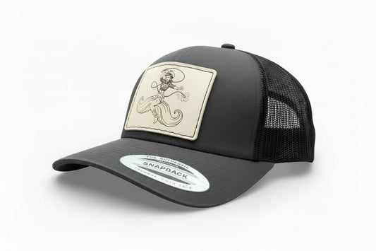 grey and black trucker hat with a decorative leather patch featuring a woman riding a moustache design.