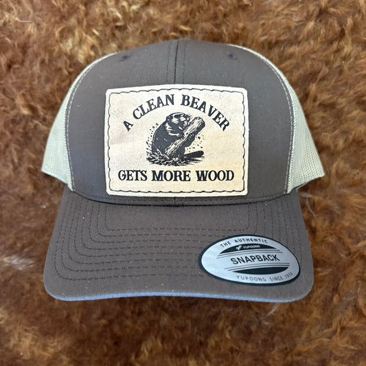 Gray and green cap with a Clean Beaver patch on a brown textured background
