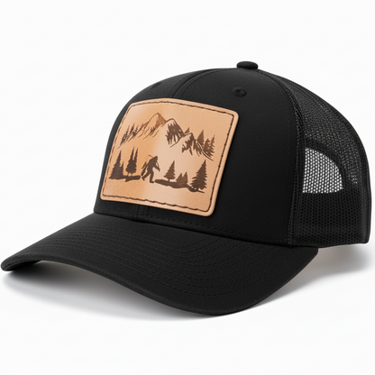 Black cap with a leather patch featuring a mountain and tree design on a white background