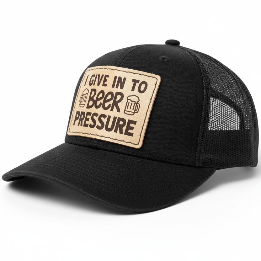 Black cap with a leather patch reading 'I give in to beer pressure' on a white background