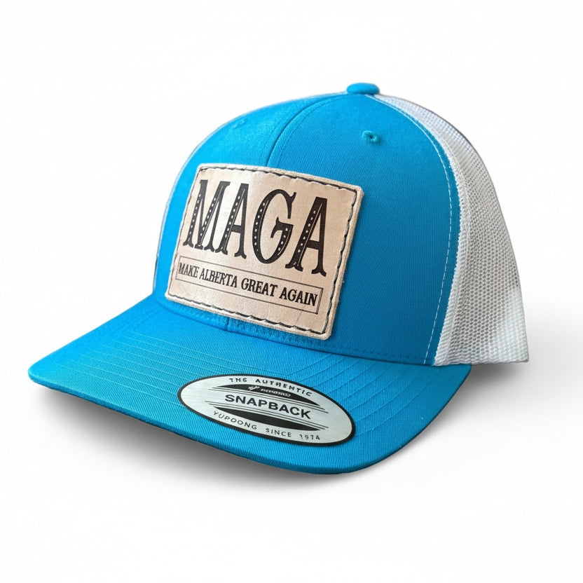 Blue and white cap with 'MAGA Make Alberta Great Again' patch on a white surface.