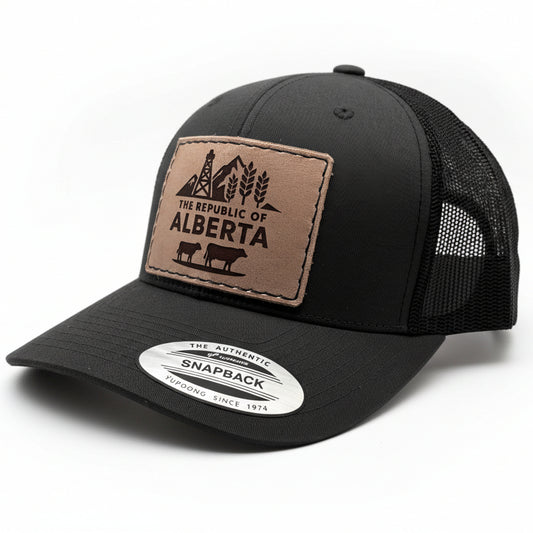 Black trucker cap with a leather patch featuring 'The Republic of Alberta' design on a white background.