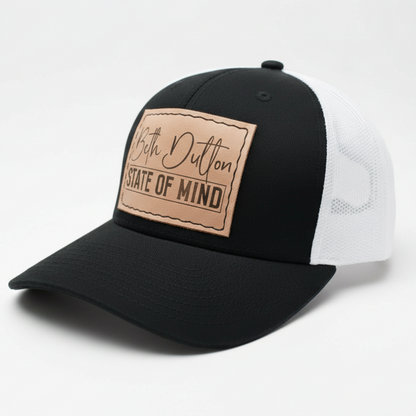 Black and white cap with a brown leather patch on a light gray background