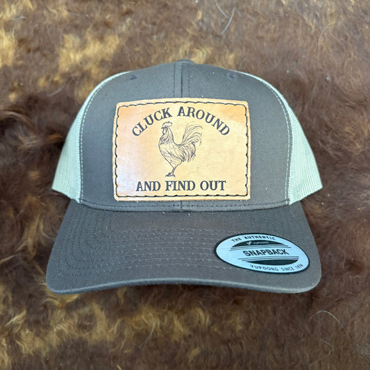 Gray cap with a leather patch featuring a rooster and text on a brown fur background