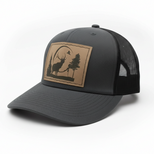 Black cap with a brown patch featuring a deer and pine tree design on a white background