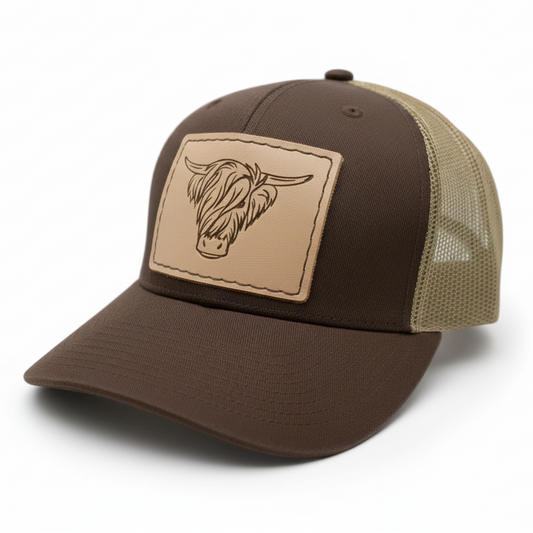 Brown and beige trucker hat with a leather patch on a white background