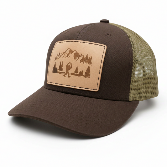 Brown and beige cap with a mountain and tree design on a white background