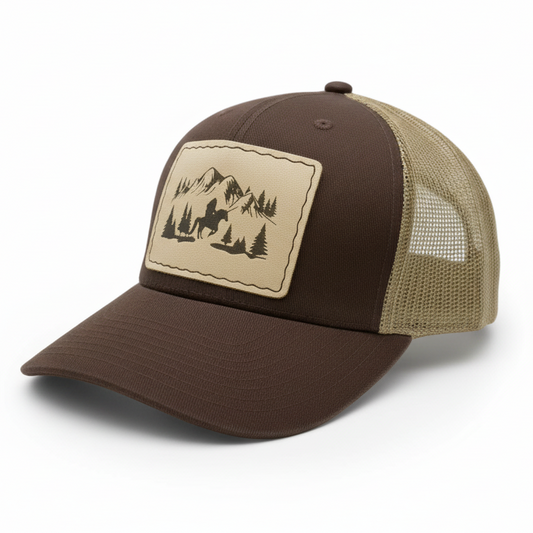 Brown and beige cap with mountain and tree design on a light gray background